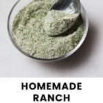 A spoon scooping homemade ranch seasoning from a small glass bowl, with text reading "Homemade Ranch Seasoning" and "cook at home mom" below.