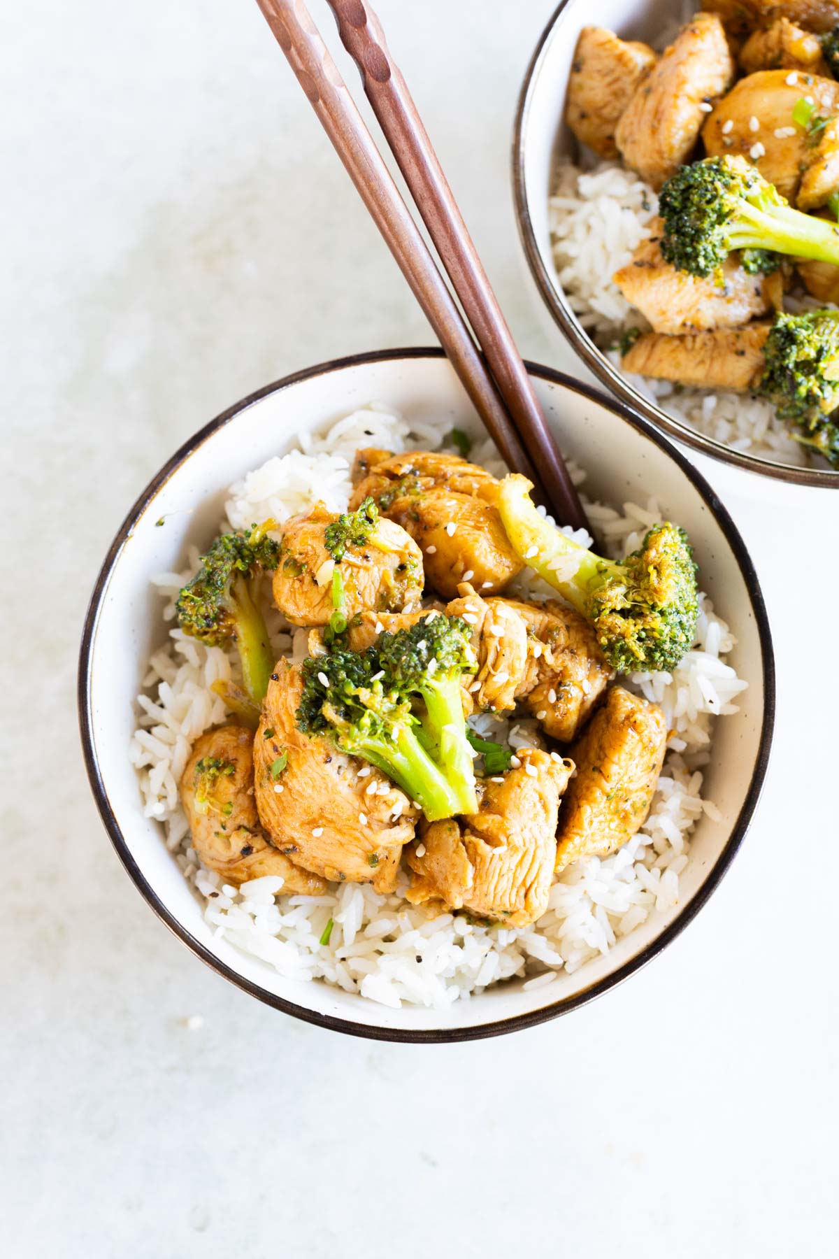Overhead view of chicken broccoli stir fry served over white rice in a bowl.