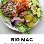 A bowl filled with lettuce, ground beef, cheddar cheese, bacon, avocado, pickles, red onion, and sauce, labeled "Big Mac Burger Bowl.