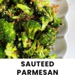 Close-up of sautéed broccoli topped with toasted breadcrumbs and grated parmesan, served on a white scalloped dish.