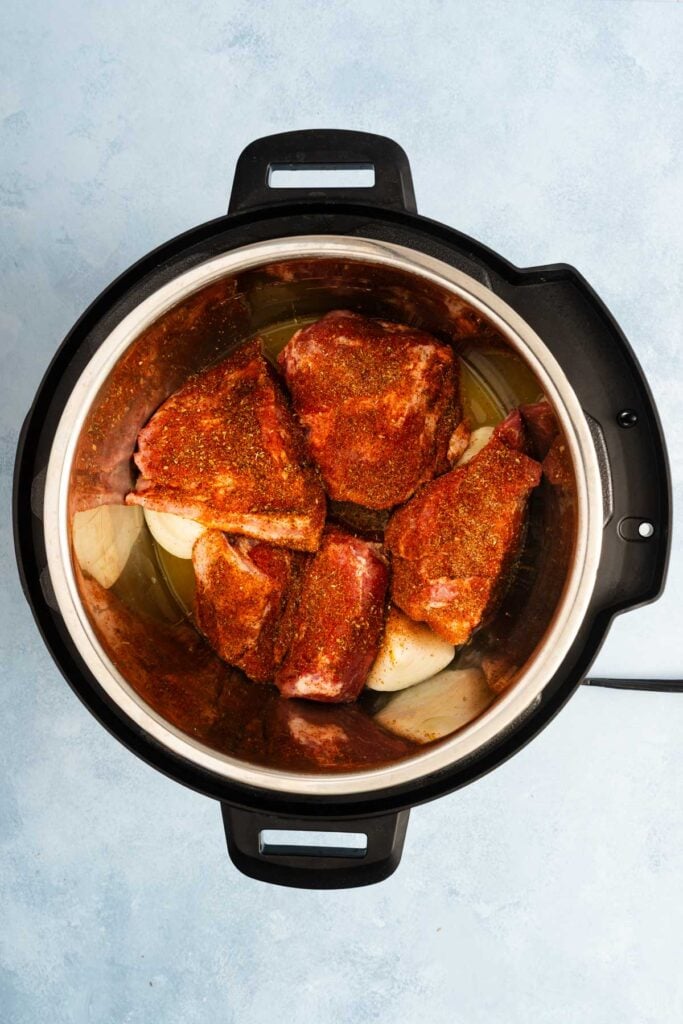 Overhead view of carnitas in an Instant Pot, ready for cooking.