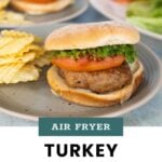 Air fryer turkey burger with lettuce and tomato on a bun, served with potato chips on a plate; sliced tomatoes and lettuce in the background. Text reads "Air Fryer Turkey Burgers.