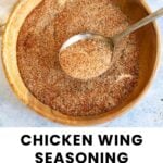 A wooden bowl filled with chicken wing seasoning dry rub and a metal spoon, with text reading "Chicken Wing Seasoning Dry Rub" at the bottom.