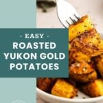 A fork holds up seasoned roasted Yukon gold potatoes over a plate, with text overlay reading “Easy Roasted Yukon Gold Potatoes.”.