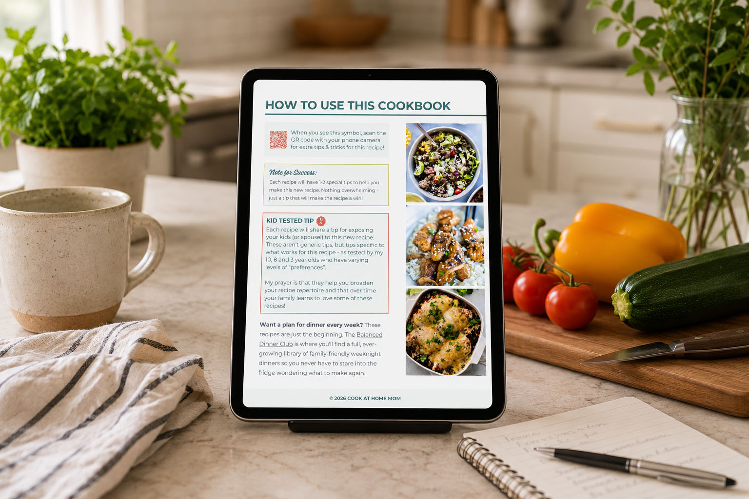 Tablet displaying a cookbook open to a "How to Use This Cookbook" page, on a kitchen counter with coffee, fresh vegetables, and a notepad nearby.