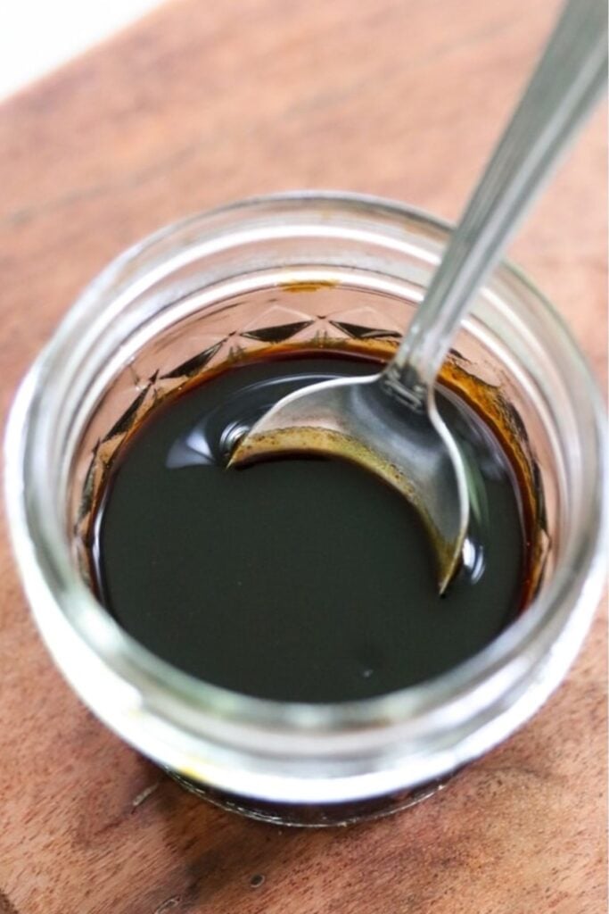 A glass jar filled with teriyaki sauce.