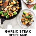 A skillet with garlic steak bites, potatoes, and broccoli. Two plates with servings of the dish are nearby, along with a bowl of salt and a sprig of parsley.